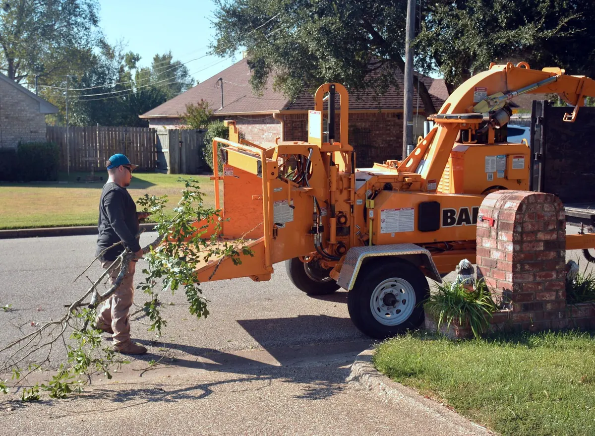 Crew operating a wood chipper in a suburban street